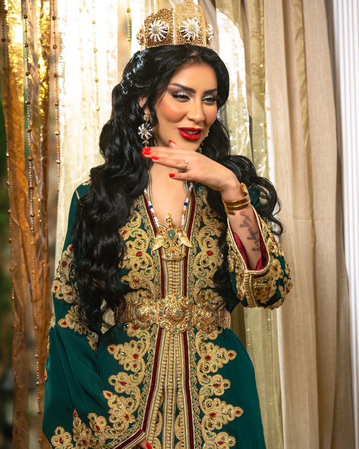Caftan En Ligne Découvrez l'élégance intemporelle du caftan henna, une pièce traditionnelle marocaine magnifiquement ornée. Nos caftans en henna allient beauté et tradition pour des moments inoubliables. Explorez notre collection unique aujourd'hui ! Le caftan se compose de deux pièces en crêpe de soie vert, ornées de broderies dorées, de perles en cristal, de sfifa et de boutons en skali doré. La partie inférieure est confectionnée en drap de soie vert, perlé à la main. Il est accompagné d'une ceinture assortie en métal.